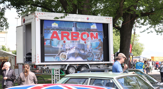 Mobiler LED Trailer mieten Mobiler LED-Screen Trailer von LED-SCREEN auf dem Eventgelände der Arbon Classics, im Vordergrund sind historische Oldtimer-Fahrzeuge und Eventbesucher zu sehen.