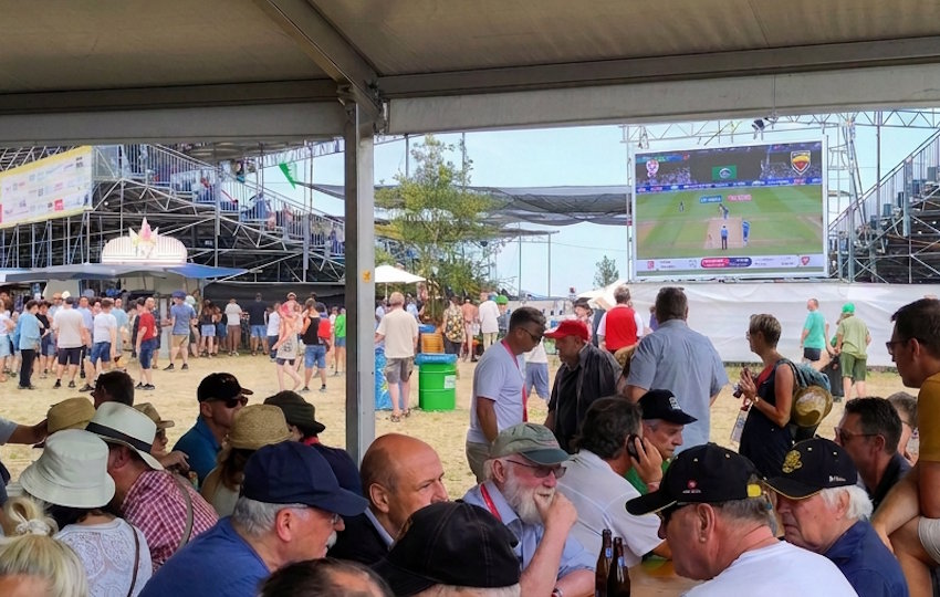 Blick aus einem gut besuchten Festzelt auf den grossen LED-Mietbildschirm, der ein Sportevent live für die Festbänke überträgt.
